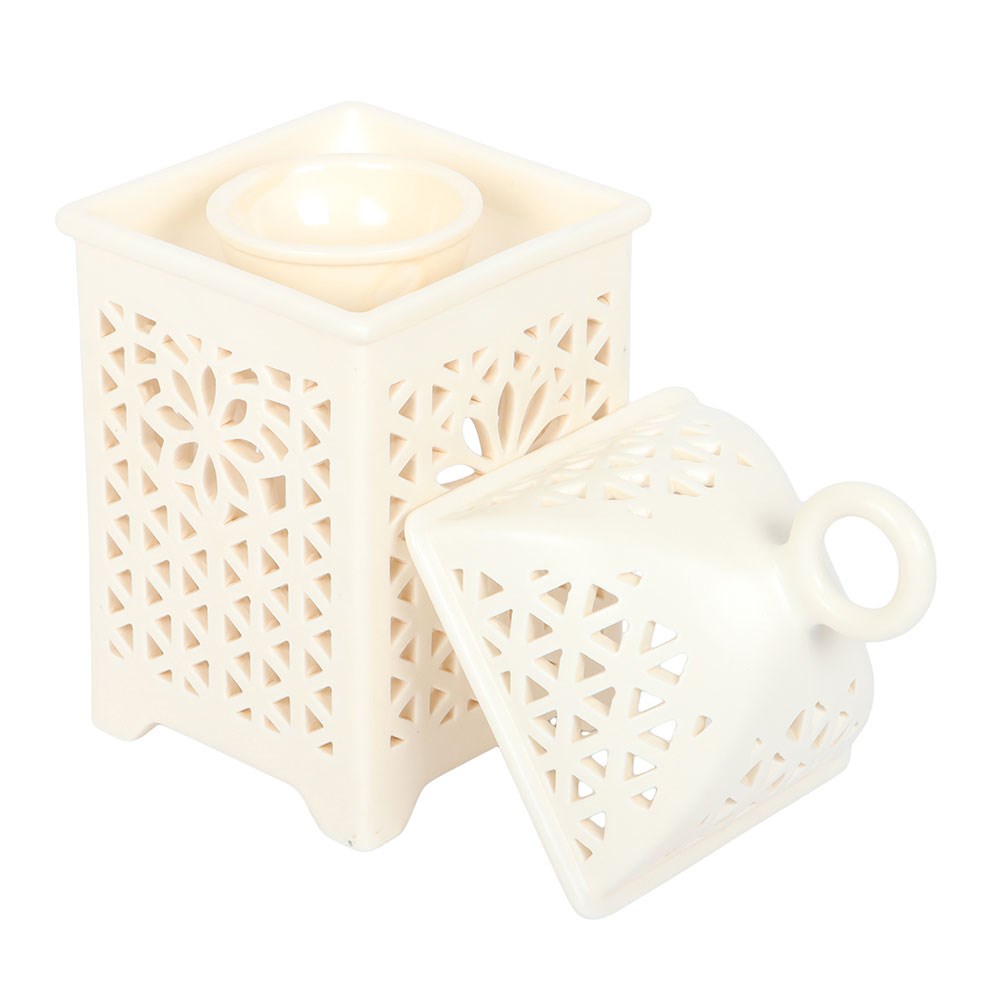 Arabian lantern burner glowing with a tealight in a cosy neutral living room setting