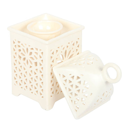 Arabian lantern burner glowing with a tealight in a cosy neutral living room setting