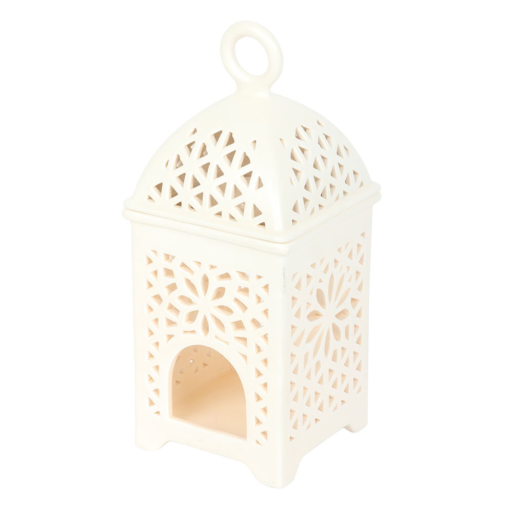 Elegant Arabian-style ceramic lantern fragrance burner displayed on a wooden side table, creating a warm and relaxing atmosphere in a cosy, neutral-toned living room.