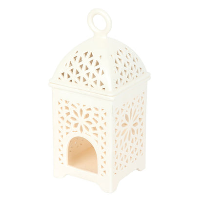 Elegant Arabian-style ceramic lantern fragrance burner displayed on a wooden side table, creating a warm and relaxing atmosphere in a cosy, neutral-toned living room.