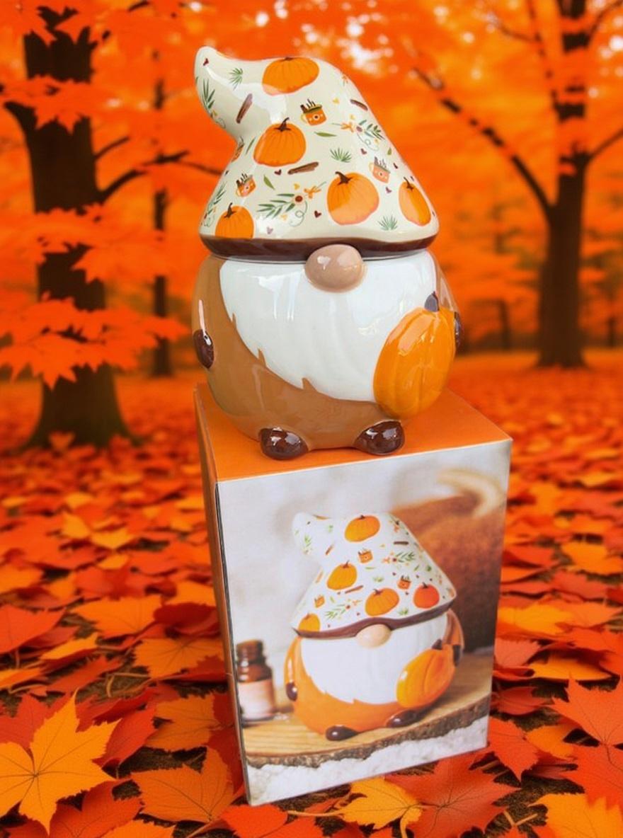 Decorative gnome with pumpkin design on a box against an autumn-themed background