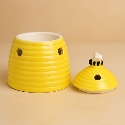 Beehive-shaped yellow ceramic tealight wax warmer on neutral background