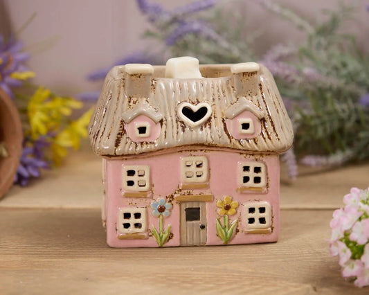 Decorative pink ceramic thatched cottage tealight holder displayed on a cosy shelf for romantic country-inspired home décor