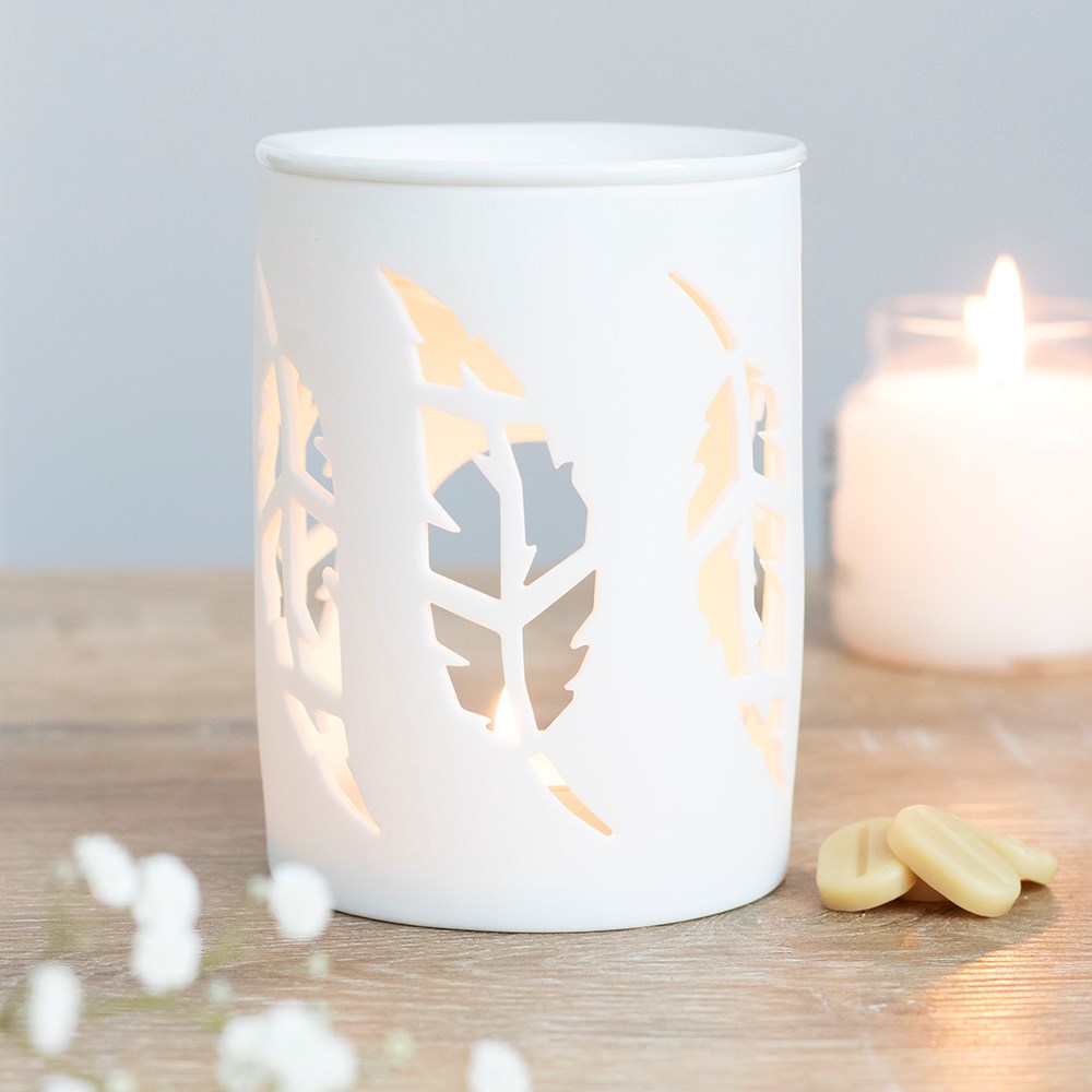 White feather wax burner styled in a cosy neutral home interior with a glowing tealight and wax melt