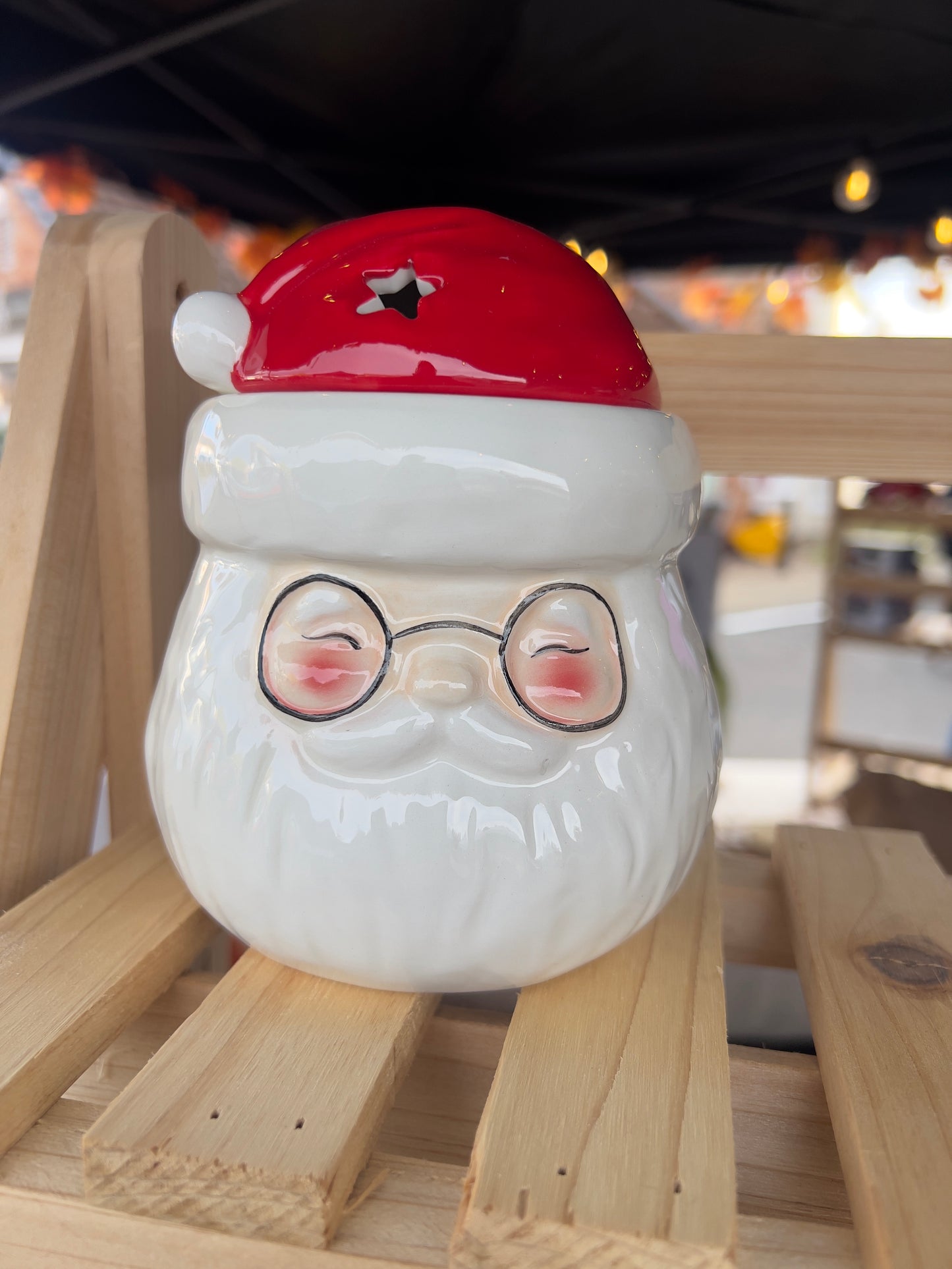 Ceramic Santa Claus wax melt and oil burner with red hat and glasses on a natural wooden display, perfect for Christmas home decor.